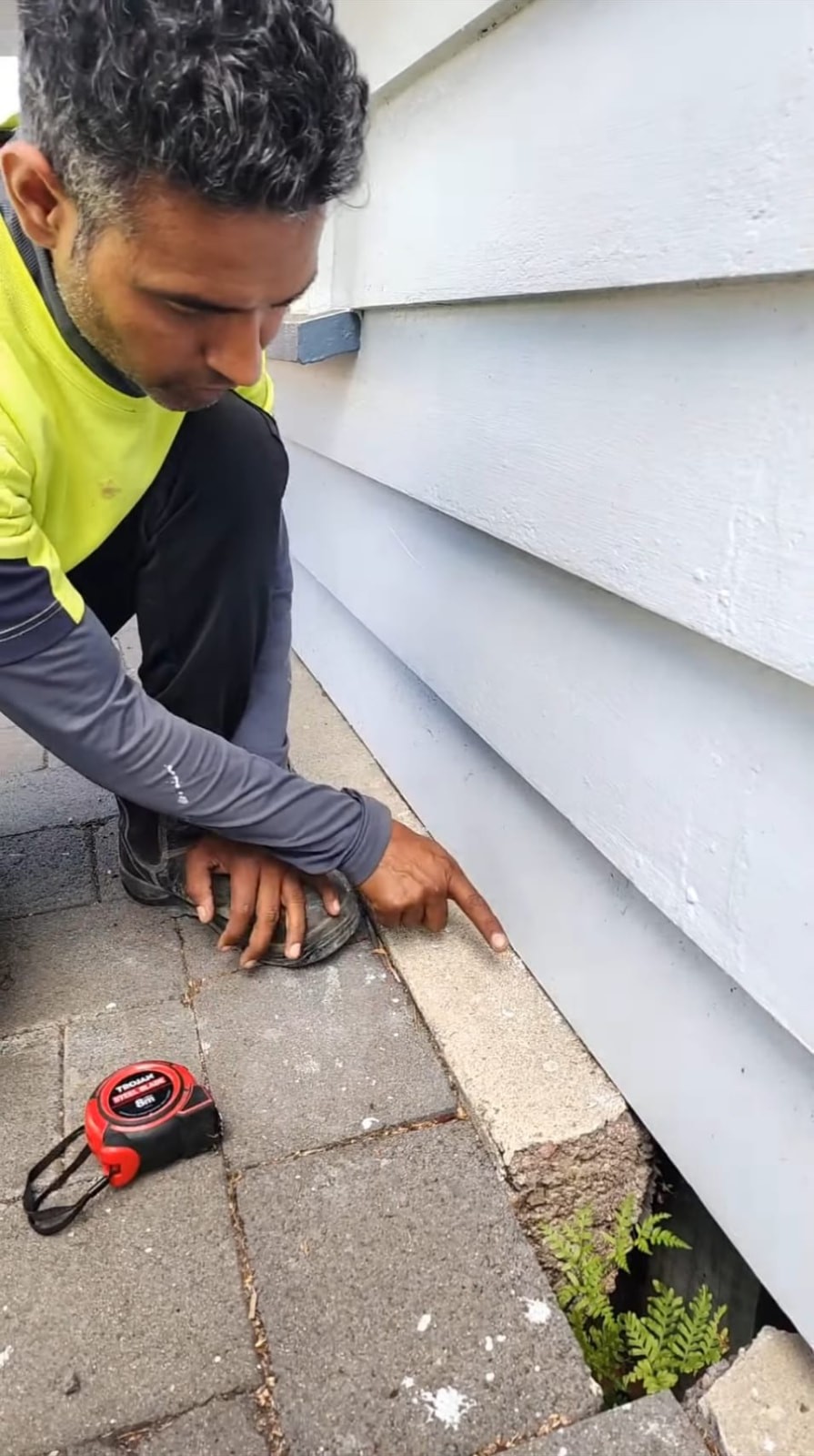 TradePlus tradesperson inspecting the cladding of an Auckland home before sale